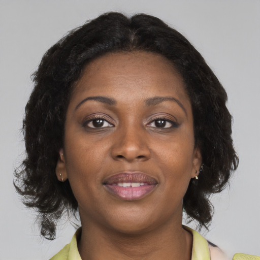 Joyful black young-adult female with medium  brown hair and brown eyes