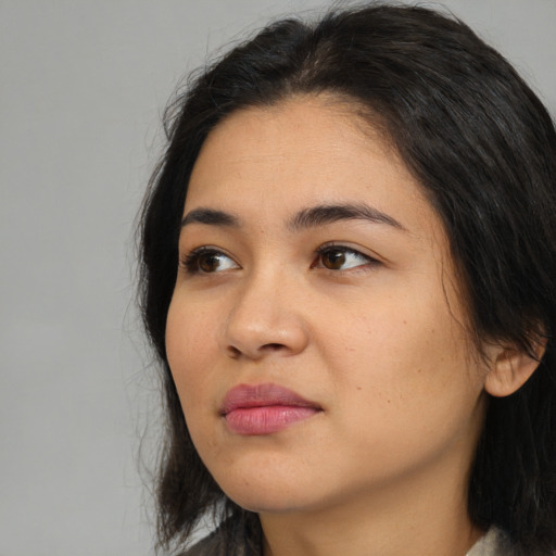 Joyful asian young-adult female with long  black hair and brown eyes