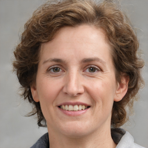 Joyful white adult female with medium  brown hair and grey eyes