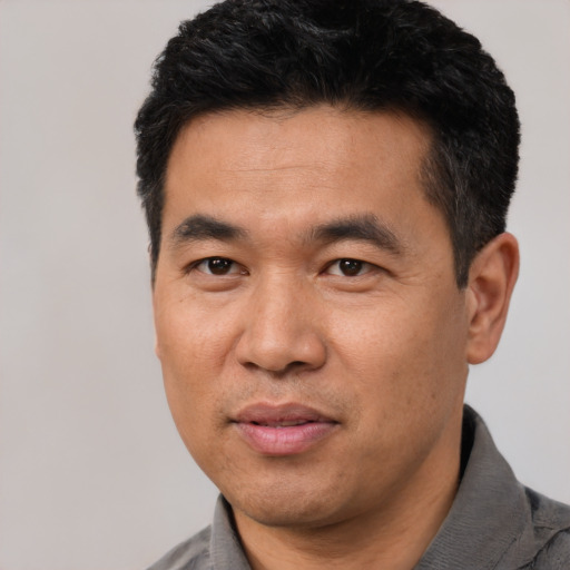 Joyful asian adult male with short  black hair and brown eyes