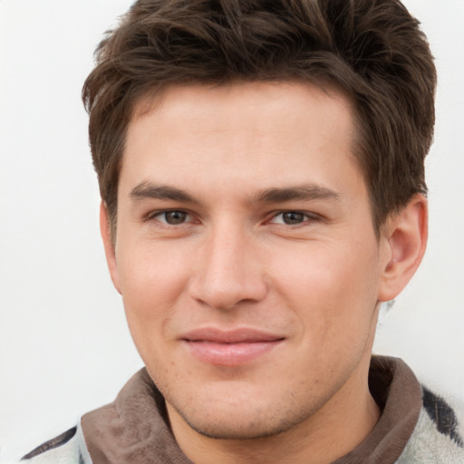 Joyful white young-adult male with short  brown hair and grey eyes