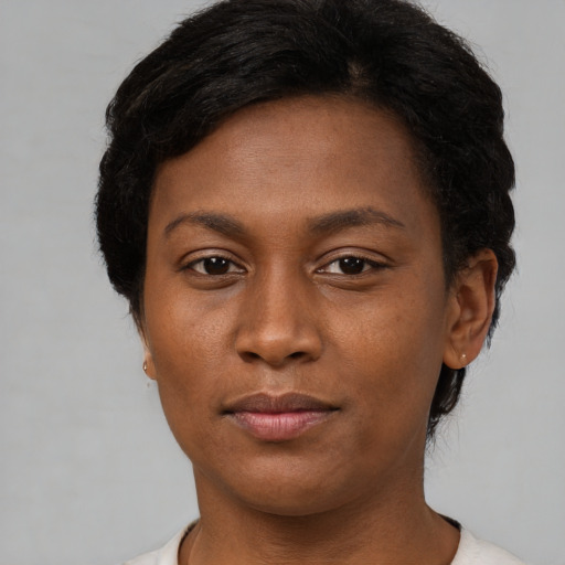 Joyful black young-adult female with short  brown hair and brown eyes