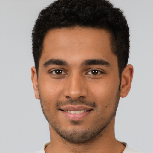 Joyful latino young-adult male with short  brown hair and brown eyes