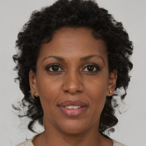 Joyful black adult female with medium  brown hair and brown eyes