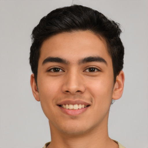 Joyful latino young-adult male with short  brown hair and brown eyes