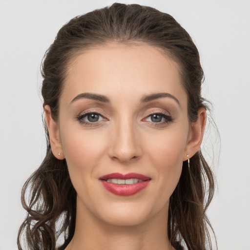 Joyful white young-adult female with long  brown hair and grey eyes