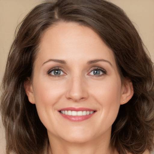 Joyful white adult female with long  brown hair and brown eyes