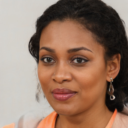 Joyful black young-adult female with medium  brown hair and brown eyes