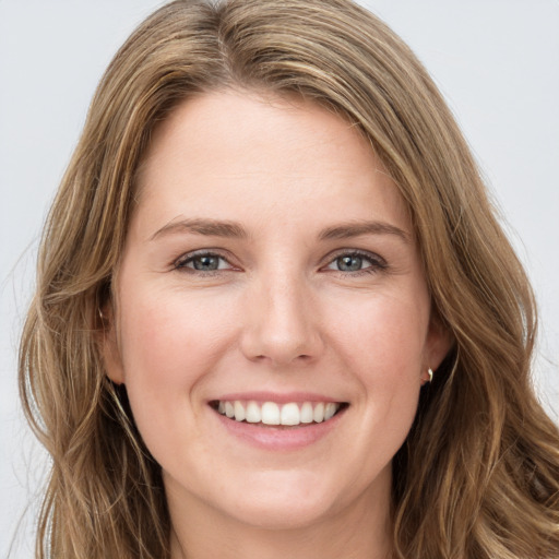 Joyful white young-adult female with long  brown hair and green eyes