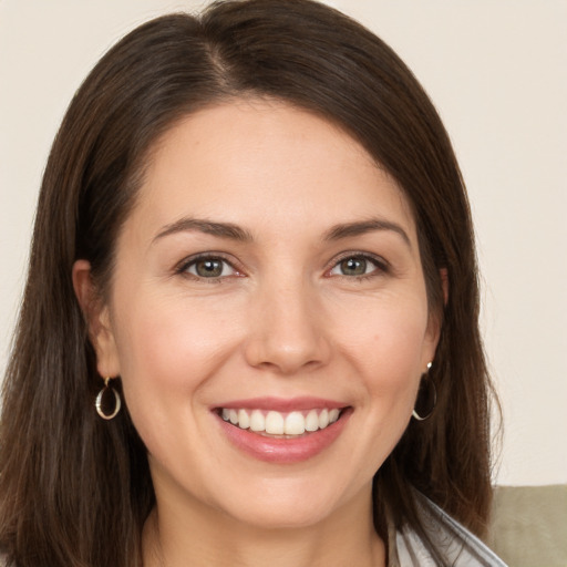 Joyful white young-adult female with long  brown hair and brown eyes