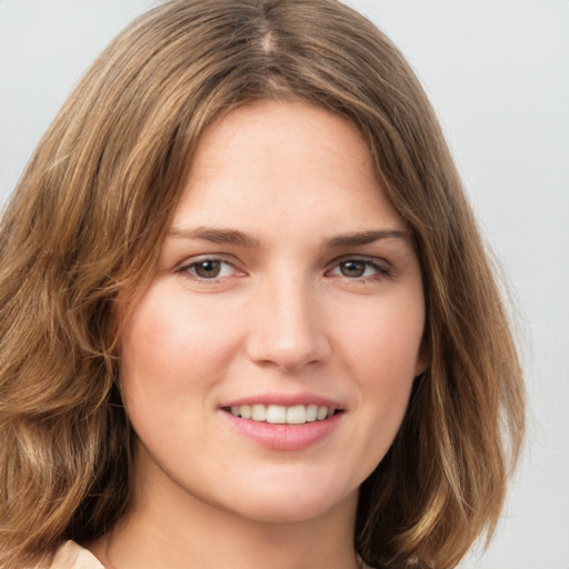 Joyful white young-adult female with medium  brown hair and green eyes