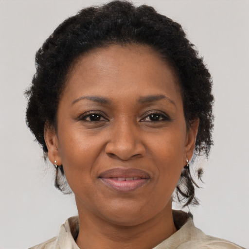 Joyful black adult female with short  brown hair and brown eyes