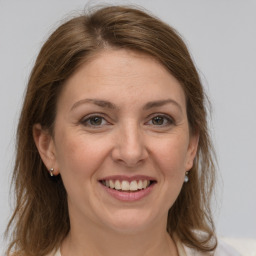 Joyful white adult female with medium  brown hair and grey eyes