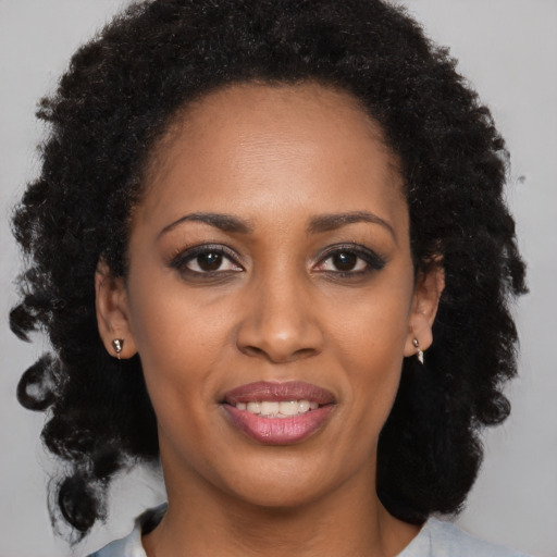 Joyful black young-adult female with long  brown hair and brown eyes