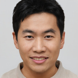 Joyful asian young-adult male with short  black hair and brown eyes