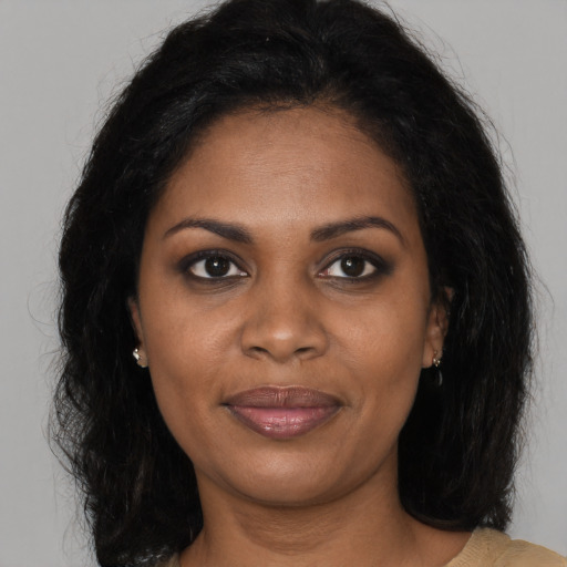 Joyful black adult female with long  brown hair and brown eyes