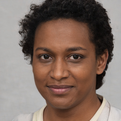 Joyful black young-adult female with short  brown hair and brown eyes