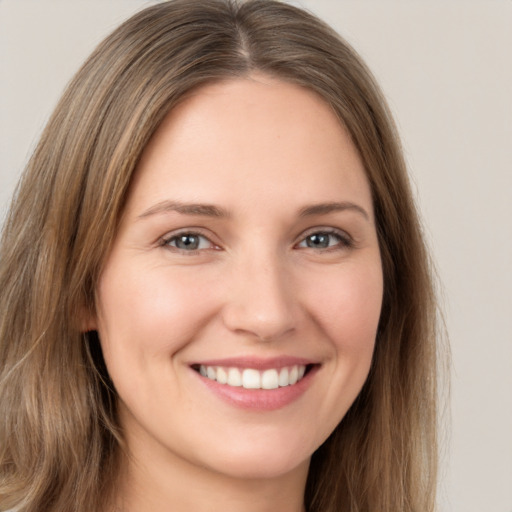 Joyful white young-adult female with long  brown hair and brown eyes