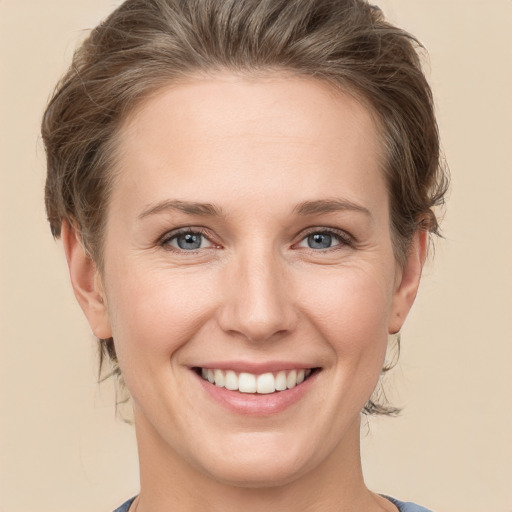 Joyful white young-adult female with medium  brown hair and grey eyes