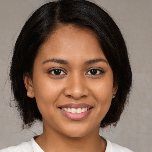 Joyful black young-adult female with medium  black hair and brown eyes