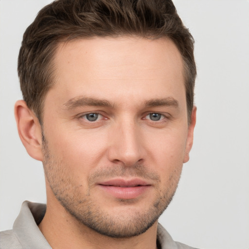 Joyful white young-adult male with short  brown hair and grey eyes