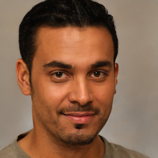 Joyful latino young-adult male with short  black hair and brown eyes
