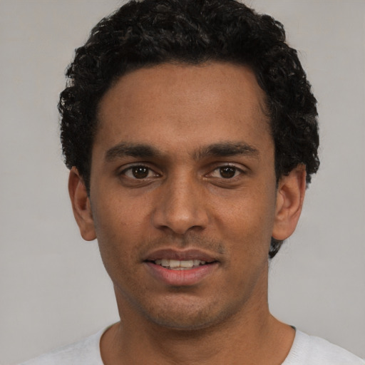 Joyful white young-adult male with short  black hair and brown eyes