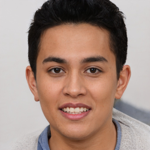 Joyful latino young-adult male with short  brown hair and brown eyes