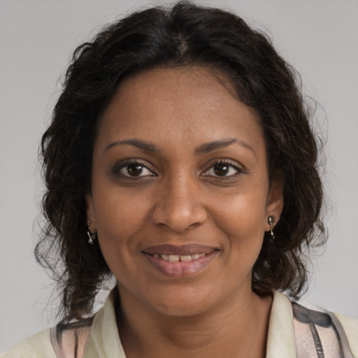 Joyful black adult female with medium  brown hair and brown eyes
