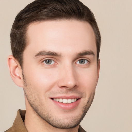 Joyful white young-adult male with short  brown hair and grey eyes