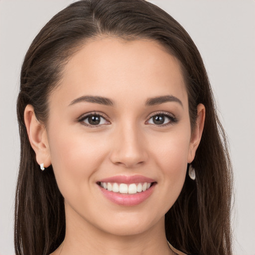 Joyful white young-adult female with long  brown hair and brown eyes