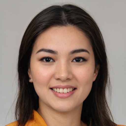 Joyful asian young-adult female with long  brown hair and brown eyes