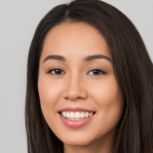 Joyful white young-adult female with long  brown hair and brown eyes