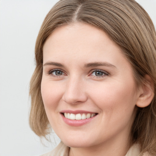 Joyful white young-adult female with long  brown hair and grey eyes