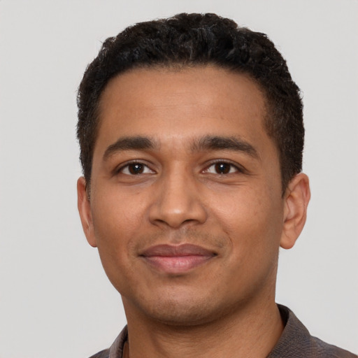 Joyful latino young-adult male with short  brown hair and brown eyes