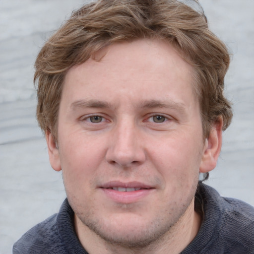 Joyful white adult male with short  brown hair and blue eyes