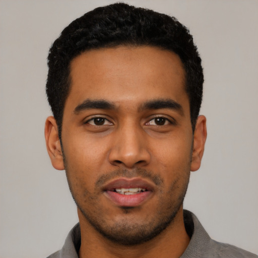 Joyful latino young-adult male with short  black hair and brown eyes