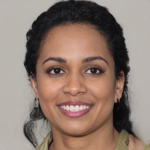 Joyful black young-adult female with short  brown hair and brown eyes