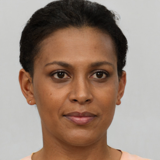 Joyful black adult female with short  brown hair and brown eyes