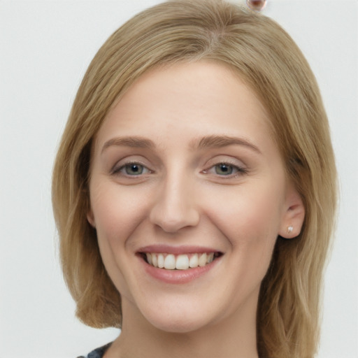 Joyful white young-adult female with long  brown hair and blue eyes