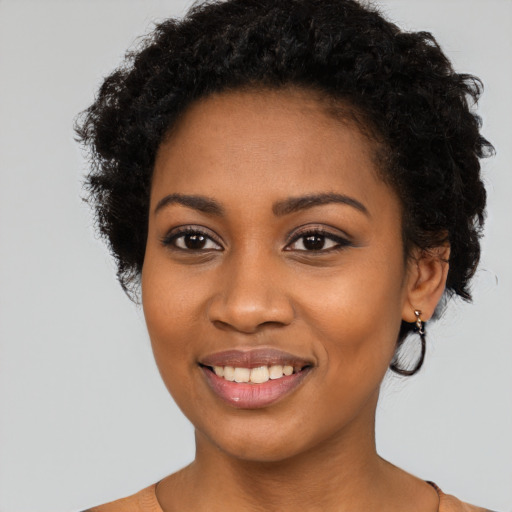 Joyful black young-adult female with short  black hair and brown eyes