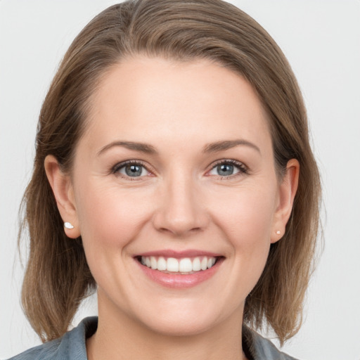 Joyful white young-adult female with medium  brown hair and grey eyes