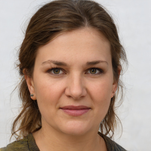 Joyful white young-adult female with medium  brown hair and grey eyes