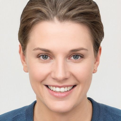 Joyful white young-adult female with short  brown hair and grey eyes