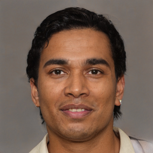 Joyful latino young-adult male with short  black hair and brown eyes