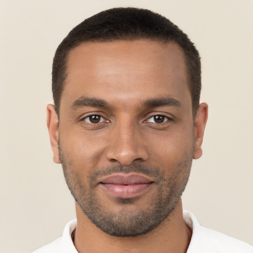 Joyful black young-adult male with short  brown hair and brown eyes