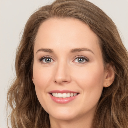 Joyful white young-adult female with long  brown hair and green eyes