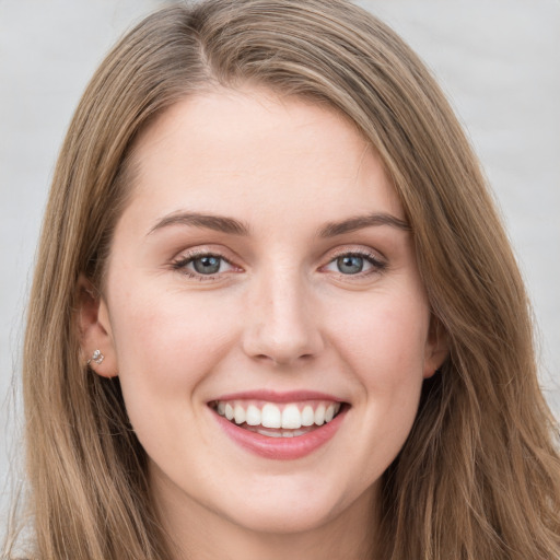 Joyful white young-adult female with long  brown hair and grey eyes