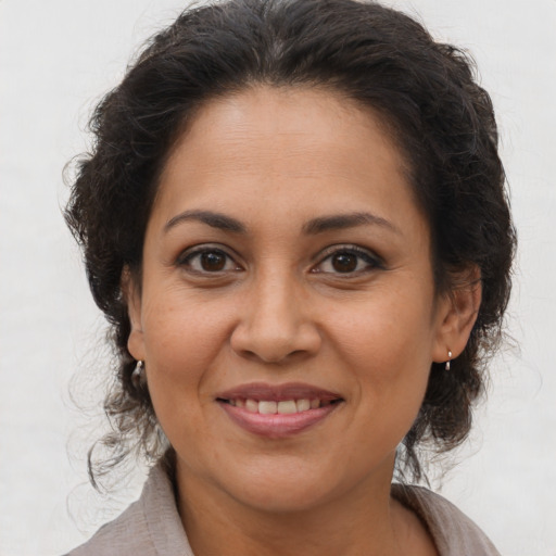 Joyful latino adult female with medium  brown hair and brown eyes