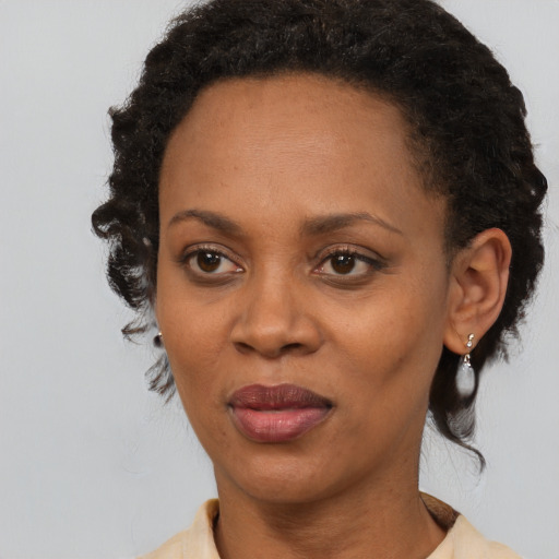 Joyful black adult female with short  brown hair and brown eyes